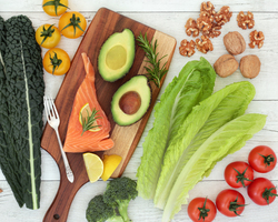 A spread of salmon, avocados, tomatoes, kale and other healthy foods.