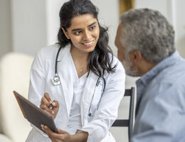 A doctor talking to an older man.