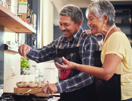 A man and woman cook together.